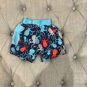 i play. Blue and Red Swim Trunks with Ocean-Themed Design